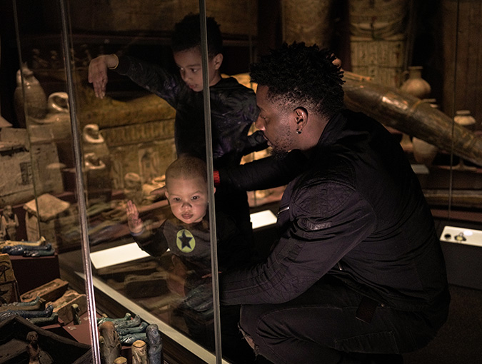 En man och två barn besöker Egypten-utställningen